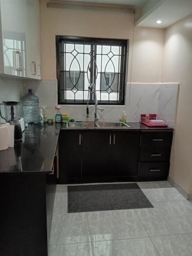 a kitchen with a sink and a window at SHOAL Apartments, Mawanda Road in Kampala