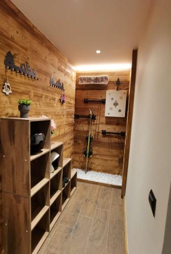 Cette chambre est dotée d'un mur en bois avec des étagères. dans l'établissement Chalet Shangrila, aux Angles
