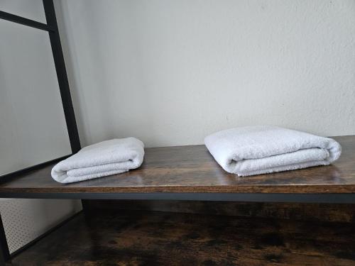 dwa ręczniki siedzą na drewnianym stole w obiekcie Residence am Rathausplatz 3 w mieście Saarbrücken