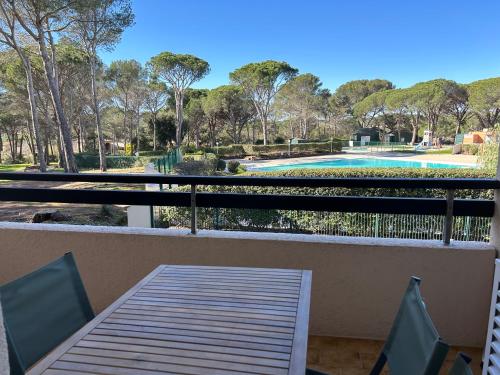 a balcony with a table and chairs and a swimming pool at Domaine Valescure vue Piscine ou Pinede - Wifi in Saint-Raphaël