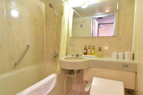 Blossom Hotel Hirosaki في هيروساكي: حمام مع حوض وحوض ومرآة