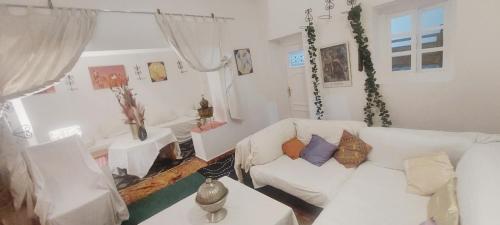 ein Wohnzimmer mit einem weißen Sofa und einem Tisch in der Unterkunft BANANa HOSTEL in Tangier