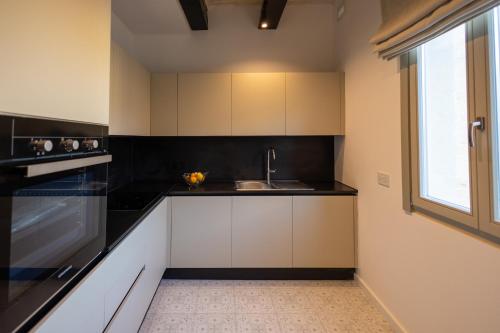 a kitchen with white cabinets and a sink and a window at Sea View 34 in Birgu