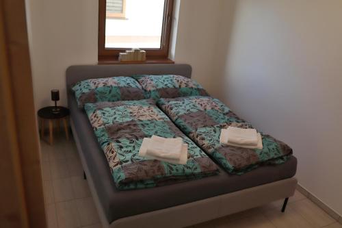 a bed in a room with two pillows on it at Apartmán na Karlíčku in Karlov