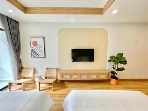 a bedroom with two beds and a flat screen tv at TMS Quy Nhơn Sea View in Quy Nhon