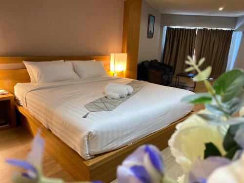 a bedroom with a bed with a stuffed animal on it at Buritel Hotel in Buriram