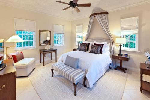 sypialnia z łóżkiem, krzesłem i oknami w obiekcie Luxury 5 BR Villa in Sandy Lane w mieście Saint James