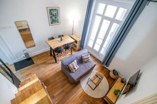 une vue aérienne d'un salon avec un canapé et une table dans l'établissement Le Brillant - Studio, à Reims