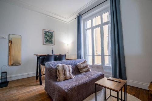 a living room with a couch and a window at Le Brillant - Studio in Reims