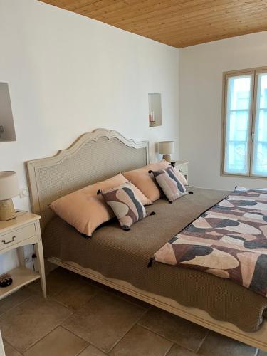 Un dormitorio con una cama grande con almohadas. en Chambres d'hôtes LES CHENES VERTS en Le Grand Vieil