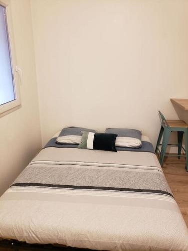 a bed sitting in a room with a window at Charmant studio à 2 pas du tram in Nantes