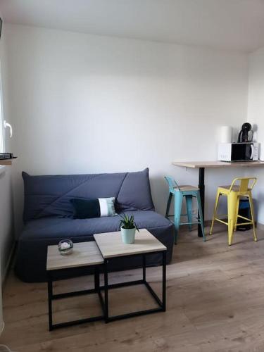 un salon avec un canapé bleu et une table dans l'établissement Charmant studio à 2 pas du tram, à Nantes