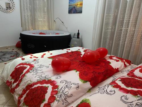 a bedroom with a bed with red flowers and a bath tub at Amazing Paradise Sensation 2 Bedroom Luxury Apartment with a Jacuzzi in Durrës