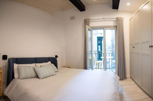 a bedroom with a large bed and a balcony at Sea View 34 in Birgu