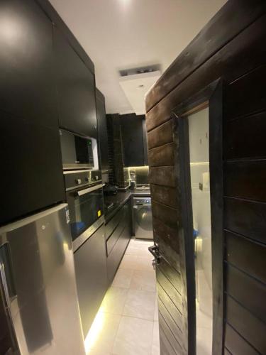 eine Küche mit einer Tür, die sich zu einer Küche mit Geräten öffnet in der Unterkunft affordable Apartment in Lagos