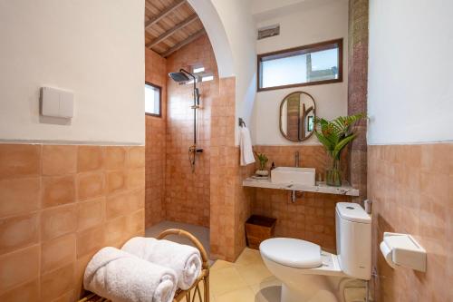een badkamer met een douche, een toilet en een wastafel bij The Kayuan Lumbur Resort Ubud in Ubud