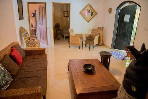 a living room with a couch and a table at Maison Jardin Botanique in Cap Skirring