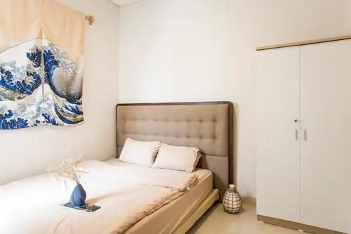 Cebu city entire place for family or party في مدينة سيبو: غرفة نوم بسرير مع لوحة على الحائط