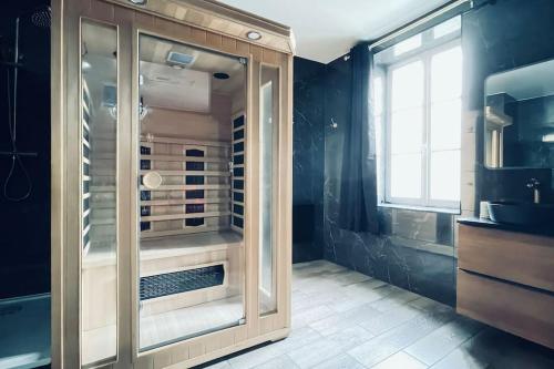 a bathroom with a large glass shower with a window at Love Room Le Baroque / Jacuzzi / Sauna in Château-Landon