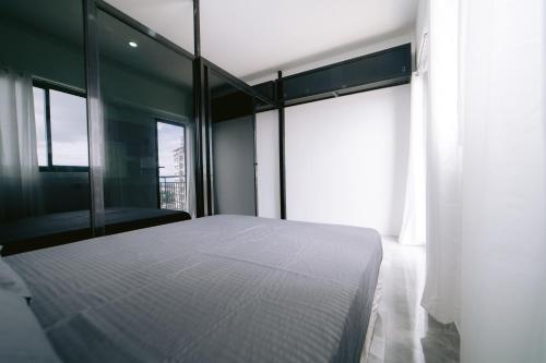 a bedroom with a white bed and large windows at Royal Oceancrest Mactan Condominium Unit 1418 in Sudtungan