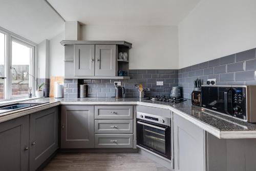 a kitchen with white cabinets and a counter top at Contract workers, Professionals, Families, Parking in Crewe