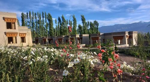 un jardín con flores frente a un edificio en Nordica Resorts Ladakh, en Leh