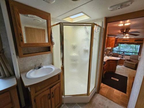 a bathroom with a shower and a sink in an rv at The Mountaineer (Presque Isle Campground #4) in Presque Isle
