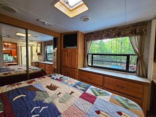 a bedroom with a bed and a window in an rv at The Mountaineer (Presque Isle Campground #4) in Presque Isle