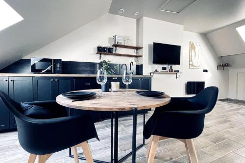 - une cuisine avec une table et 2 verres à vin dans l'établissement Love Room Le Chalet / Jacuzzi / Sauna, à Château-Landon