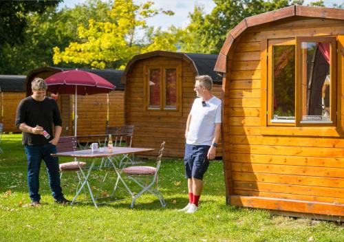 two men standing in front of a small cabin at Rheingau 524 Schlaffassdorf direkt am Rhein in Geisenheim