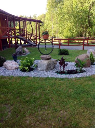 a garden with a fountain in the grass at Globepark in Mažonai