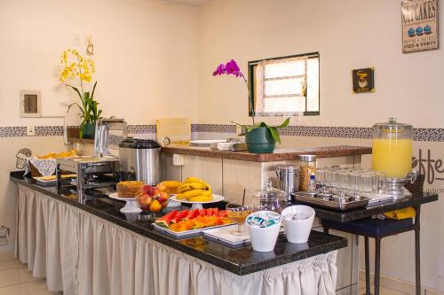 una cocina con un montón de comida en un mostrador en Hotel Pousada Rosim, en Pirassununga