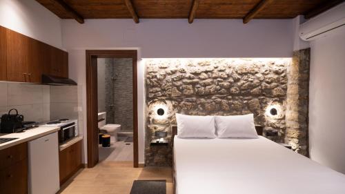 ein Schlafzimmer mit einem großen weißen Bett in einer Küche in der Unterkunft Πέτρινη Αγροικία 2 Stone Manor 2 in Kastraki