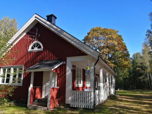 Sinnerskog - Urlaub im alten Bahnhof في Högsby: مبنى احمر عليه علم