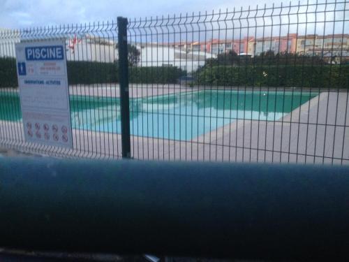 une clôture en face d'une piscine dans l'établissement Vacances mer piscine Méditerranée Le Cap d’agde studio cabine parking et 2 plages à 250 Mètres, au Cap d'Agde