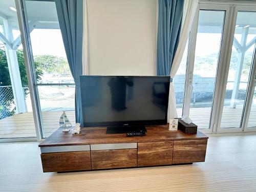 a flat screen tv sitting on top of a wooden dresser at 唐津 海辺の家 in Fuchinoue