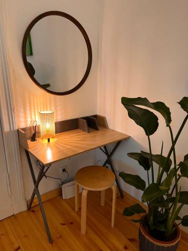 a desk with a mirror and a stool and a plant at Cosy Studio Akazienkiez in Berlin