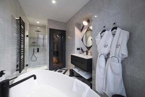 a bathroom with a white tub and a sink at Grand Hôtel Du Parc - Teritoria in Aix-les-Bains