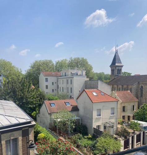 un groupe de bâtiments dans une ville avec une église dans l'établissement APPARTEMENT AU COEUR DES JEUX OLYMPIQUES., à LʼÎle-Saint-Denis