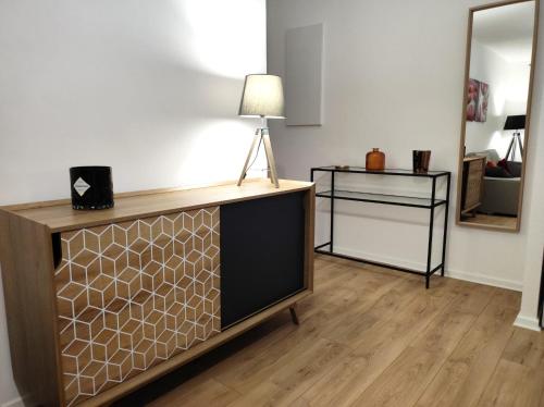 een woonkamer met een tv en een lamp op een dressoir bij Rien que pour vous in Reichstett