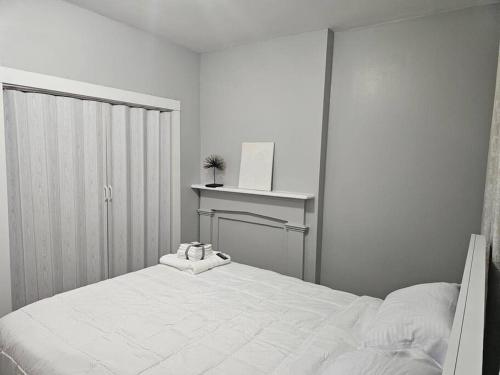 Habitación blanca con cama y escritorio en Fortune Suits and Apartment en Albany