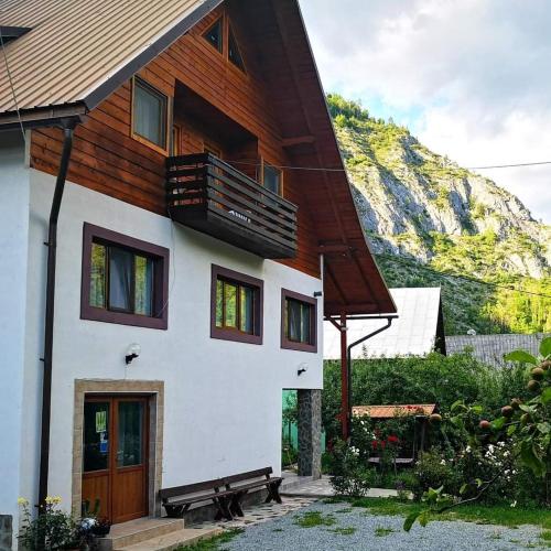 a house with a wooden roof and a balcony at Pensiunea Piatra Mandrutului in Scărişoara