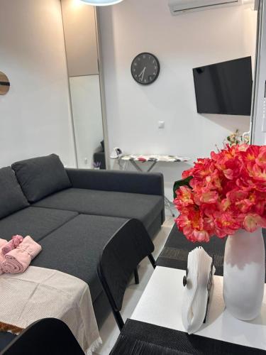 a living room with a couch and a vase of flowers at Artemis Beach Holiday Nest 1 in Artemida