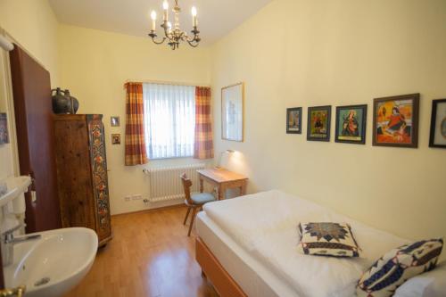 ein Schlafzimmer mit einem Bett und einem Waschbecken sowie ein Badezimmer in der Unterkunft Gästehaus Englischer Garten in München