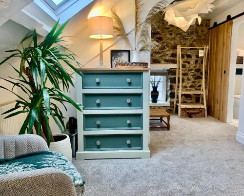 ein Schlafzimmer mit einer blauen Kommode mit einer Pflanze in der Unterkunft Blas at Fronlas Café - The heart of Newport in Newport