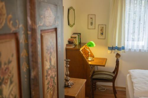 a bedroom with a desk and a bed and a chair at Gästehaus Englischer Garten in Munich