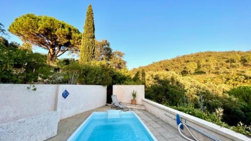 une piscine dans une cour arrière avec une clôture et des arbres dans l'établissement La petite maison sur la colline - Piscine privée, à La Londe-les-Maures