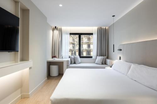 um quarto branco com uma cama grande e uma janela em Royal Ramblas em Barcelona