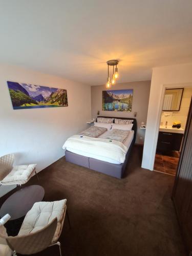 een slaapkamer met een bed en stoelen erin bij Ferienwohnung Ambiente in Garmisch-Partenkirchen