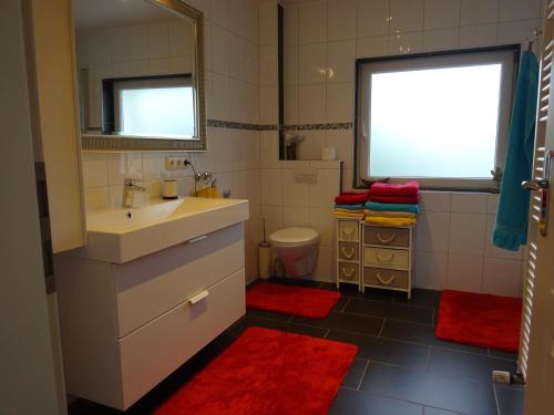 een badkamer met een wastafel, een toilet en een raam bij Ferienwohnung Ambiente in Garmisch-Partenkirchen